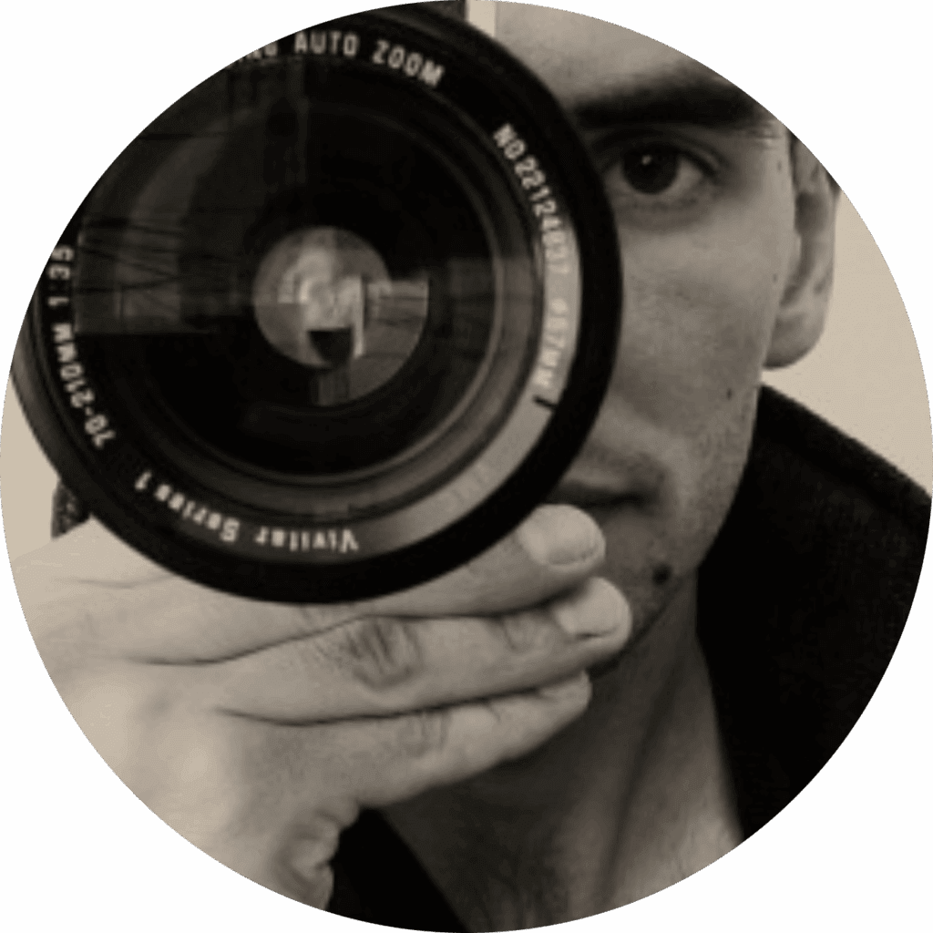 person holding a camera lens in front of their face